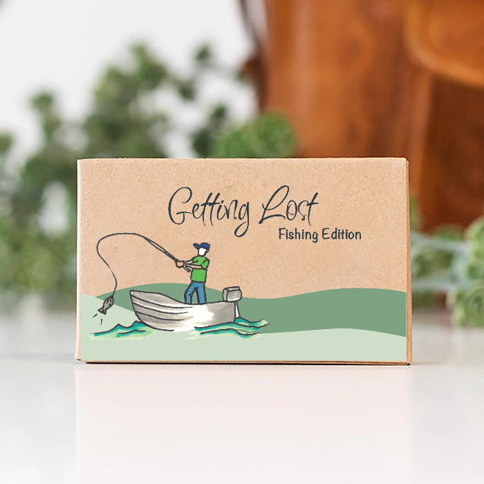 Getting Lost Fishing Edition card game box with an angler casting from a boat, Adventure Awaits
