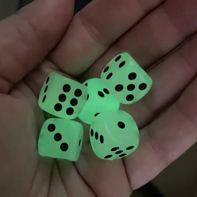 Hand holding five glow-in-the-dark dice with black dots glowing green — Adventure Awaits