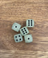 Five glow-in-the-dark dice with black dots on a wooden tabletop — Adventure Awaits
