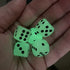 Hand holding five glow-in-the-dark dice with black dots glowing green — Adventure Awaits