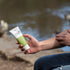 Applying Good Riddance insect repellent by the river, natural mozzie protection for camping and outdoor travel Adventure Awaits