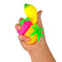 Hand holding a colorful squishy toy shaped like a banana with a pink fruit on a white background