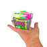 A hand holding a packaged novelty product labeled 'Groovy Nee Doh Fruit' against a plain white background. The product inside the clear plastic box appears to be a bright pink and green squishy toy or novelty item.