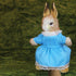Stuffed rabbit toy in a blue dress with a green background, featuring the Hansa brand.