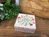 Decorative floral gift box with “You Make the World a Better Place” message on a rustic wooden table