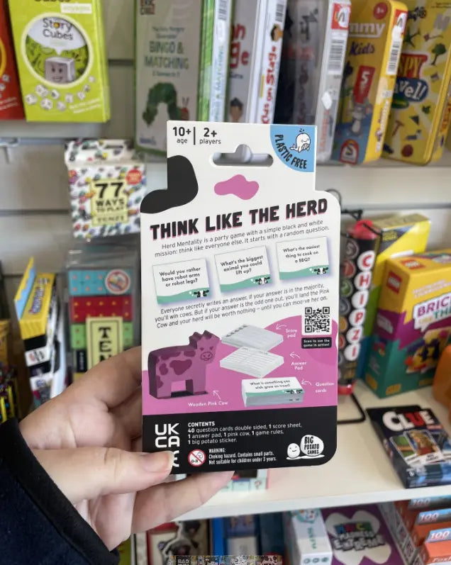 Back of Herd Mentality party game pack with Think Like The Herd rules and pink cow art Adventure Awaits