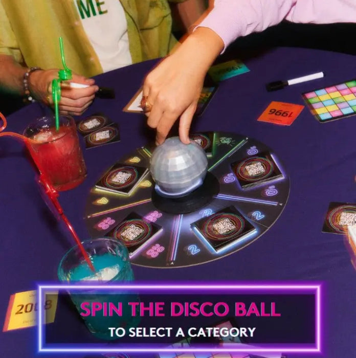 People playing HITSTER Music Bingo, spinning the disco ball to choose a category — Adventure Awaits