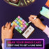 Player marking a colourful HITSTER Music Bingo card while using a phone — Adventure Awaits