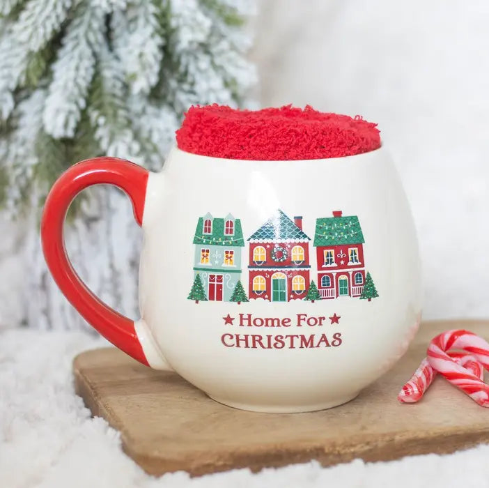 Home for Christmas ceramic mug with red handle, festive houses and red fluffy socks — Adventure Awaits