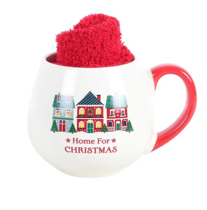 Home for Christmas ceramic mug holding red fluffy socks with festive house design — Adventure Awaits