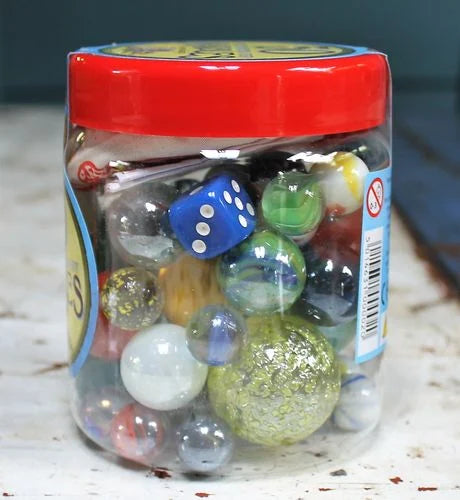 Jar of marbles with a blue die on a marble surface