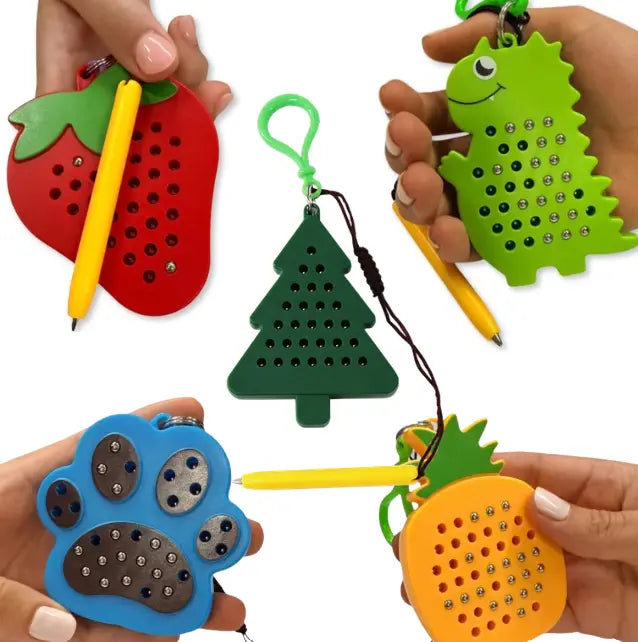 Assorted Kaiko magnetic pad keyrings in strawberry, dinosaur, tree, paw and pineapple designs — Adventure Awaits