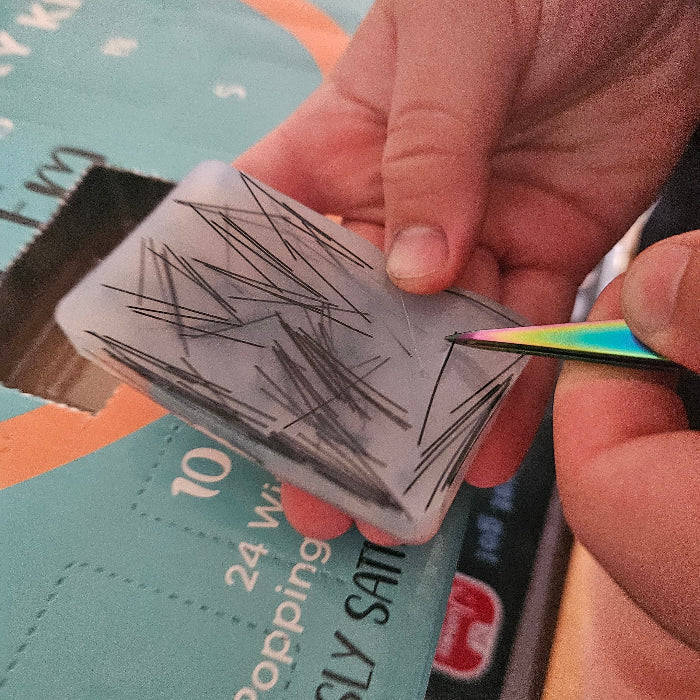 Person using a tool to remove hairs from a silicone fidget pad
