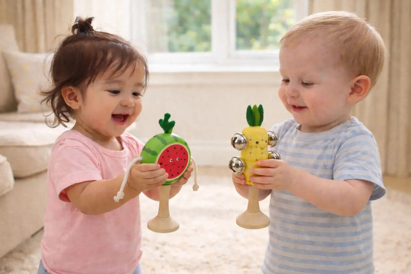 Toddlers playing with wooden fruit music set twist drum and bell stick — Adventure Awaits