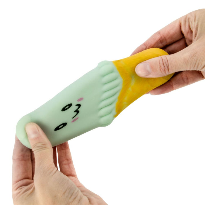 hands stretching soft green ice cream squishy toy with cute face and yellow cone, stretchy sensory toy for kids play and stress relief Adventure Awaits