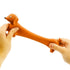 hands stretching stretchy sausage dog toy showing long elastic body, fun sensory toy for squeezing and stretching during play at home or travel Adventure Awaits