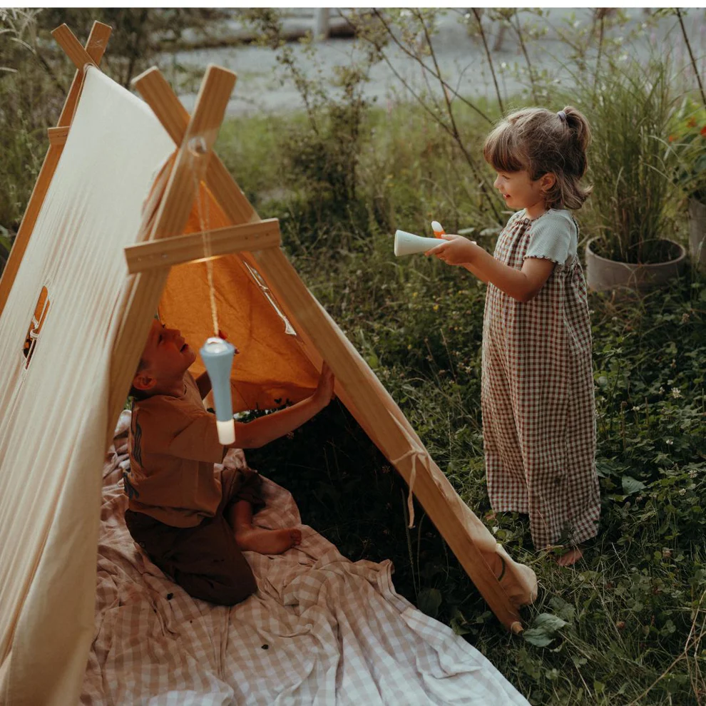 Adventure Awaits children using portable LED night lights beside a canvas play tent outdoors at dusk