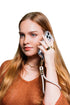Woman takes a call with her phone secured by a grey wrist strap with gold clasp, Adventure Awaits
