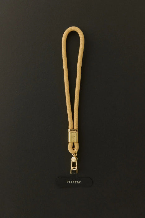 Tan Klipsta phone wrist strap with gold clasp and phone connector tab, Adventure Awaits