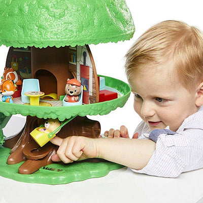 Child playing with a toy treehouse set on a white background