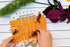 child weaving ribbon and florals through square wooden nature weaving frame - Adventure Awaits