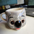 Ceramic mug shaped like a koala with a smiling expression on a white surface.