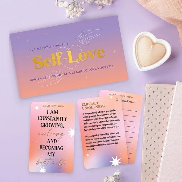 Self-Love card game with affirmation, uniqueness and journalling cards beside heart candle — Adventure Awaits