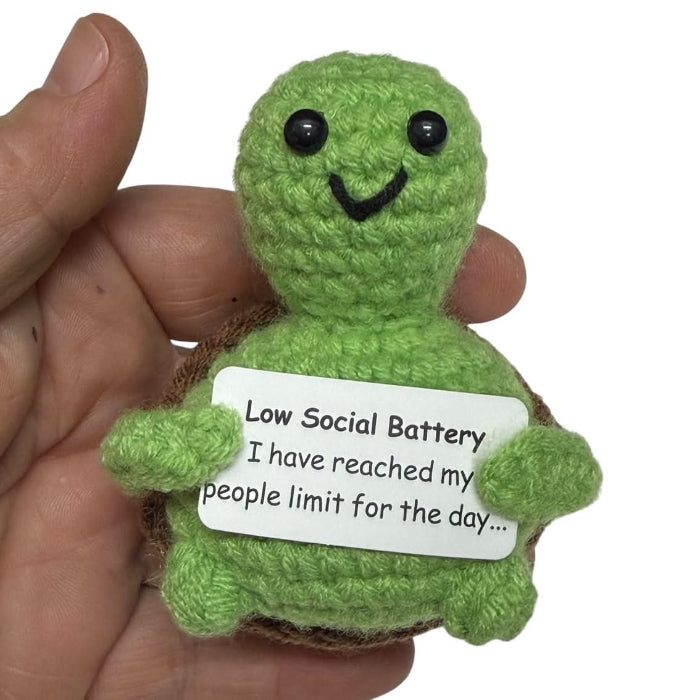 handmade crochet turtle plush toy holding a “Low Social Battery” sign about reaching the people limit for the day