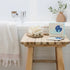 Lula self warming eye mask box styled in bathroom setting on wooden stool, ideal for relaxation and restful sleep at home or travel Adventure Awaits
