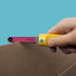 Hand uses the yellow Makedo Safe-Saw to cut corrugated cardboard with its child-safe serrated blade — Adventure Awaits