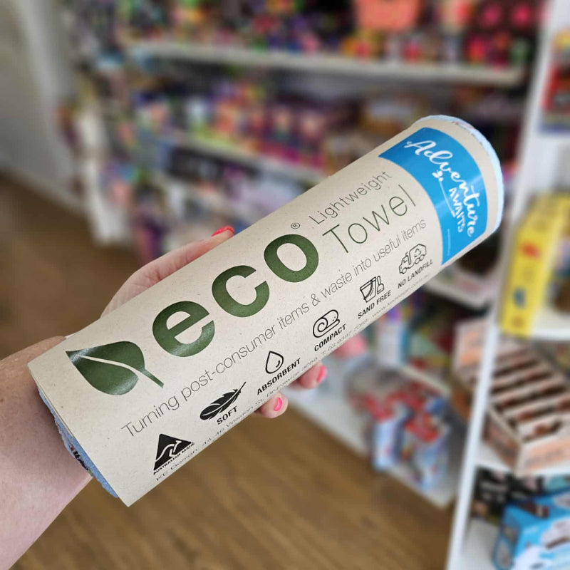 Hand holding an eco-friendly product package in a store setting