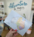 Map of Australia held by a hand with 'Adventure Awaits' text in the background