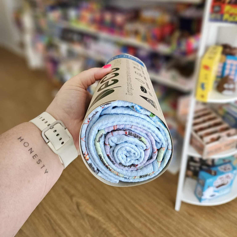 Person holding a rolled-up fabric product with a store shelf in the background