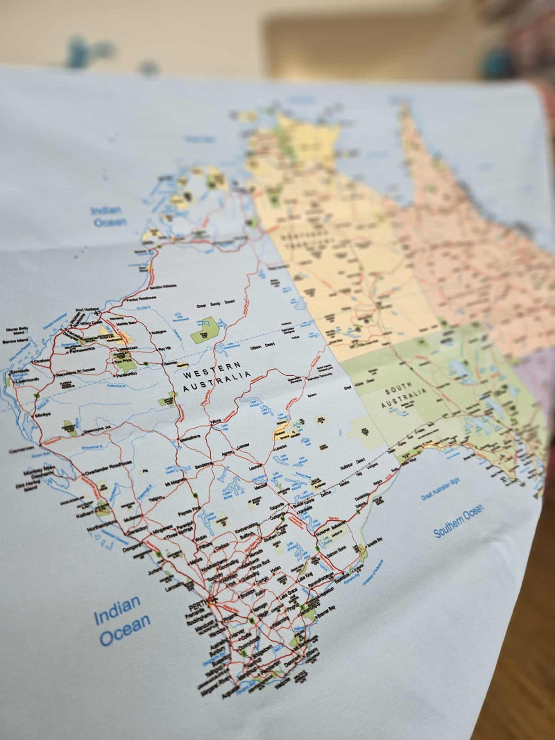 Map of Australia with labeled states and roads on a textured surface.