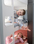 Two children relaxing in caravan bunk beds wearing pyjamas inside a modern family camper interior