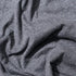 Close up of soft charcoal grey fabric with a textured knit finish and natural draped folds