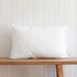 White pillow on wooden bench against panelled wall, soft comfortable bedding essential for home or travel use Adventure Awaits