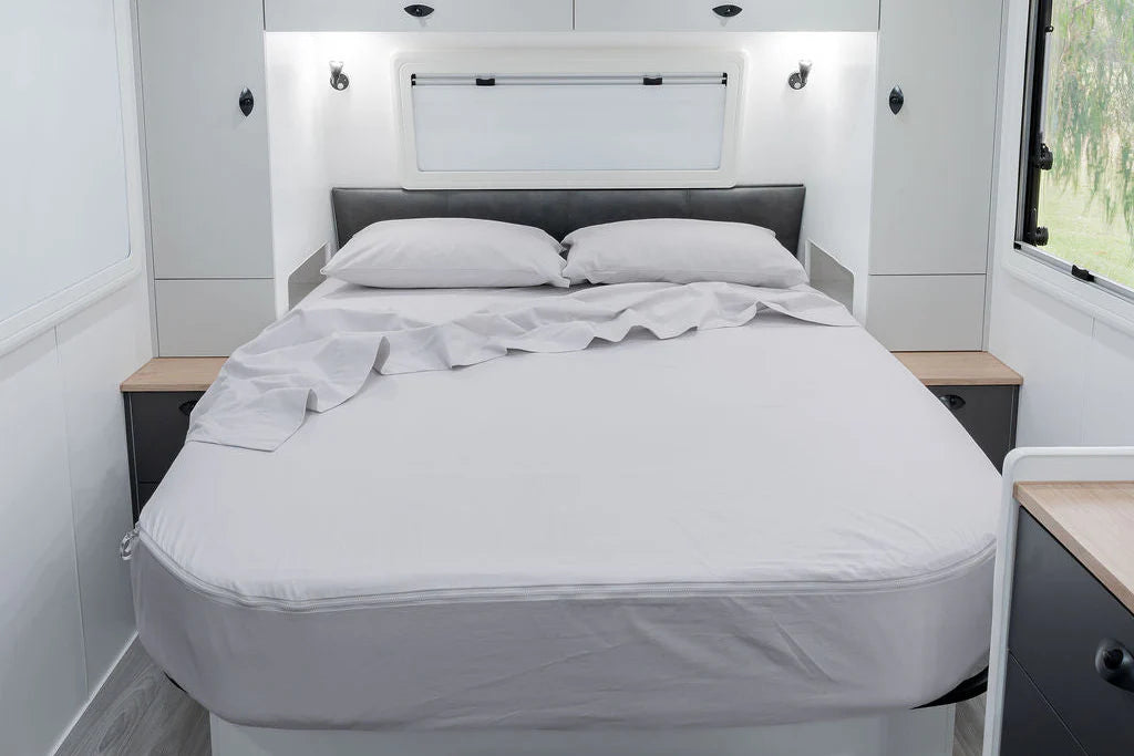 MeanderWild driftwood flannelette sheet set on a queen caravan bed with overhead window and reading lights — Adventure Awaits
