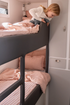 Child climbing onto a bunk bed in a compact room