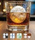A clear glass tumbler with a large spherical ice ball on top, filled with amber liquid, shown on a wooden surface. Four small inset circles at the bottom show different ice ball patterns labeled Golf Balls, Basketball Balls, Soccer Balls, and Footy Balls.
