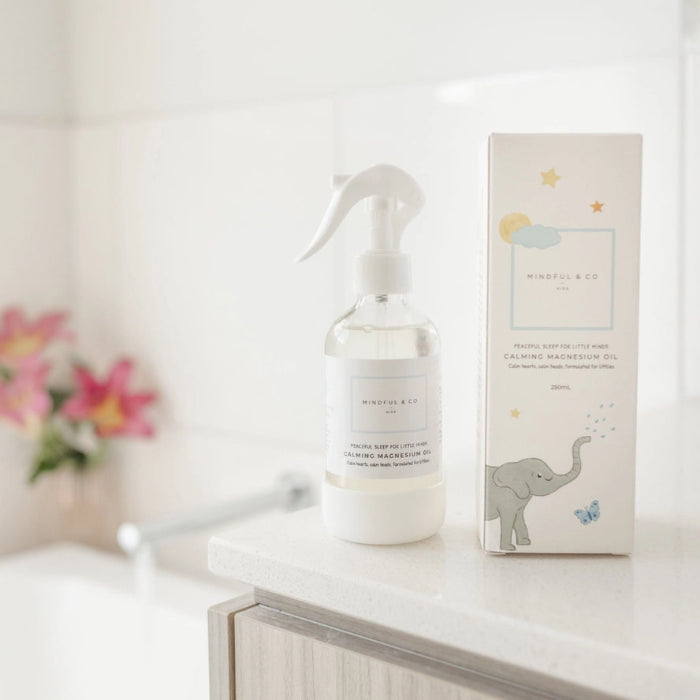 Mindful and Co calming magnesium oil spray bottle with packaging on bathroom counter, gentle sleep support for babies and children at home or travel Adventure Awaits