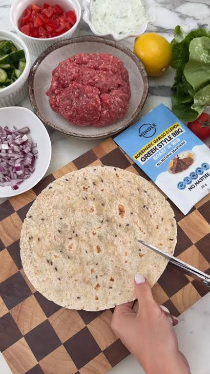 Mingle Greek Style BBQ seasoning beside beef mince, flatbread, salad ingredients and tzatziki — Adventure Awaits