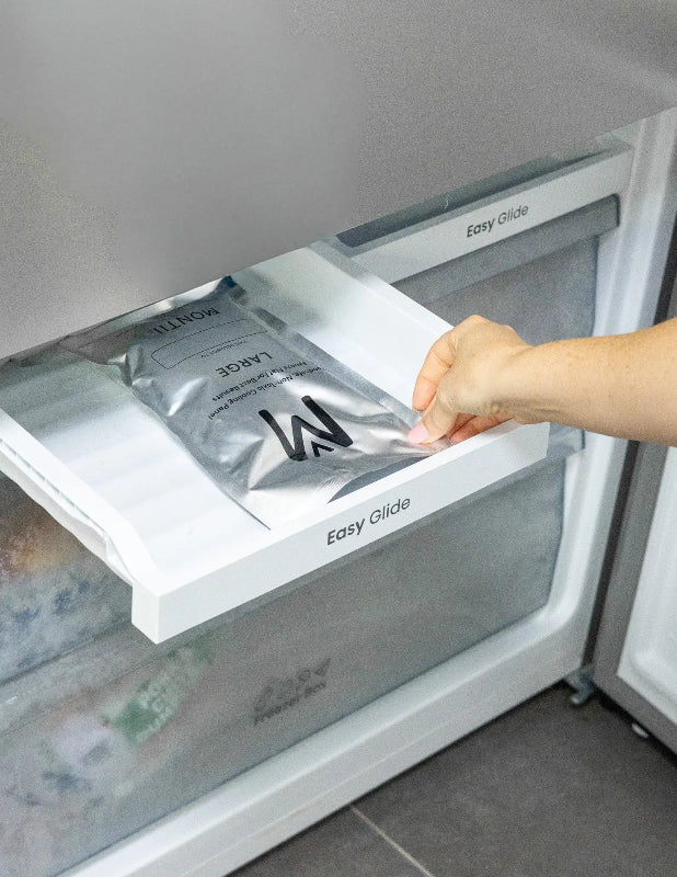 Hand placing a Montii large cooling panel flat in a freezer drawer — Adventure Awaits