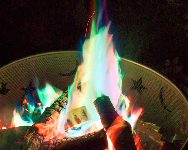 Colourful flames in a fire pit with decorative stones.