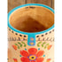 Close up of a cowboy boot shaped ceramic mug interior with colourful floral detailing and “live happy” text