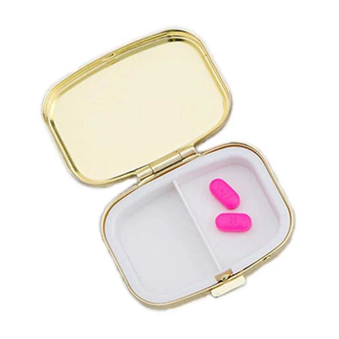 Happy Pills gold pill box open showing interior mirror lid and two-compartment tray with pink capsules — Adventure Awaits