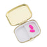 Happy Pills gold pill box open showing interior mirror lid and two-compartment tray with pink capsules — Adventure Awaits