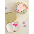 Happy Pills gold pill box open showing mirror and two compartments, styled on glittery sand with flowers — Adventure Awaits