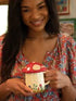 Woman holding red mushroom mug with lid, whimsical ceramic gift for cosy tea or coffee at home Adventure Awaits