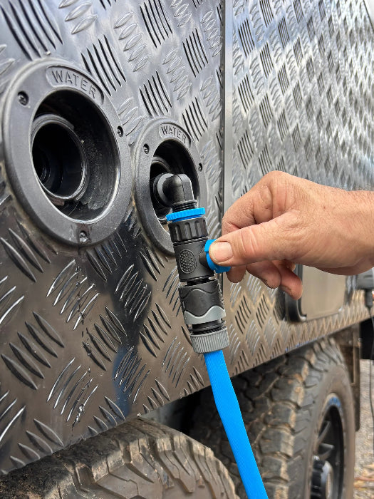 Hand adjusts the Navigator Tank Filler Buddy valve while filling a caravan water tank - Adventure Awaits